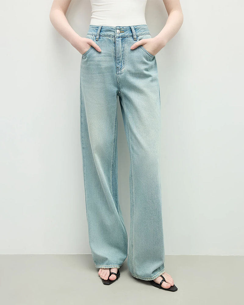 Woman street-styling distressed high-waist straight jeans, sun-fade indigo wash and knee-slit rips give lived-in 90s attitude—92 % cotton / 6 % poly / 2 % elastane keeps structure while adding stretch for 60-75 °F spring-fall days.