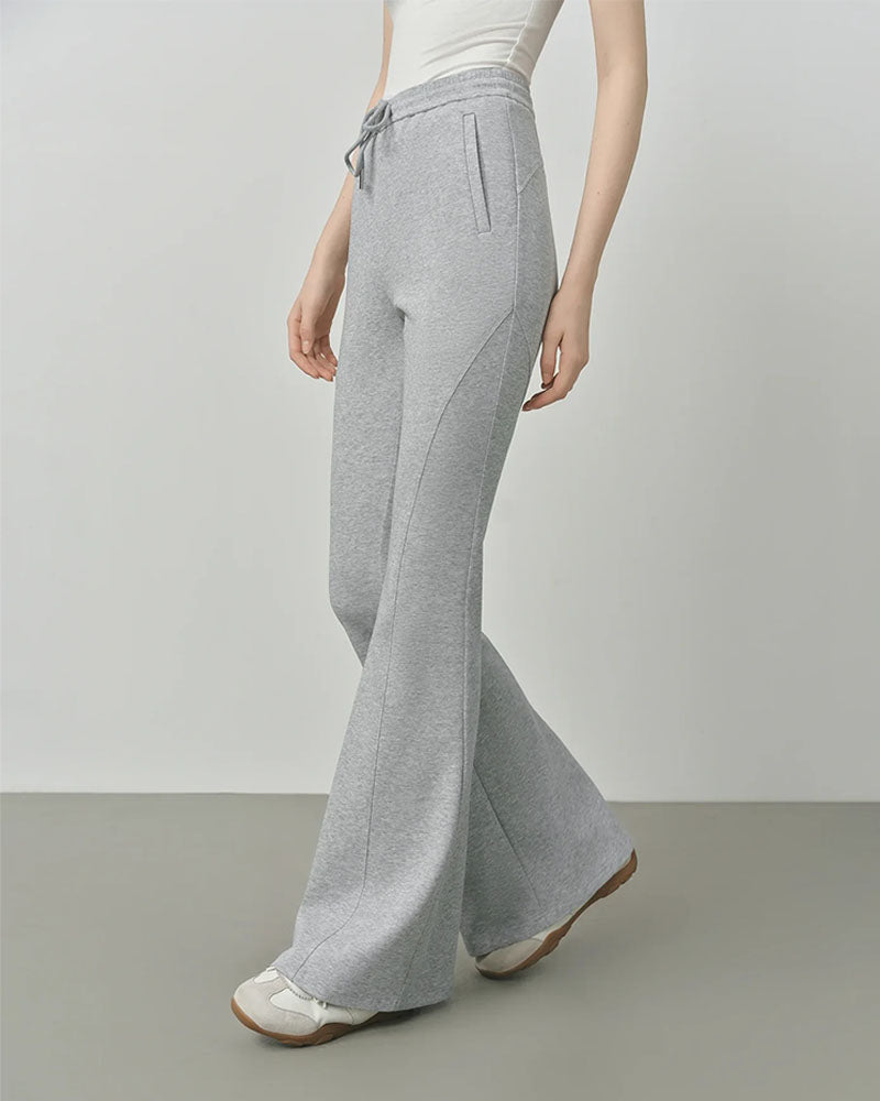 Woman striding in retro slim-fit flared pants, 360° stretch corduroy hugs from waist to knee then flares over boots—your 70s throwback for 60-75 °F spring-fall commutes.