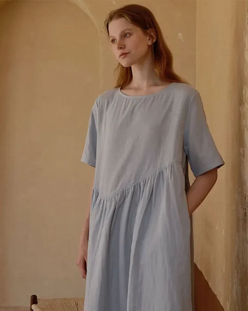 Woman drifting off in a cloud-white 100 % cotton double-layer nightdress, airy gauze lining keeps you cool while the outer jersey offers modest coverage—perfect for warm summer nights.