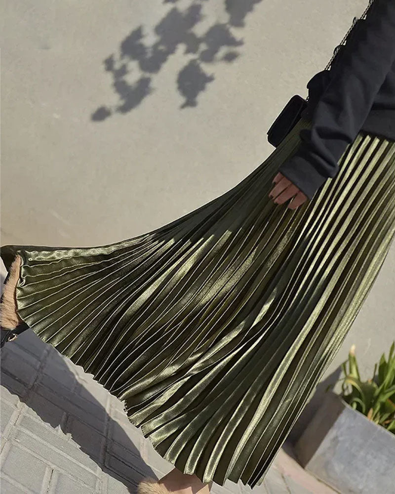 Woman twirling in a velvet high-waist pleated skirt, rich emerald pile catches the light while the 32-inch midi hem skims boots—your luxe statement for 50-70 °F fall-through-spring dinners.