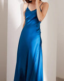 Woman posing in a 100 % real silk V-neck sling dress, mid-calf length skims gracefully—luxurious mulberry fibers catch the light for elegant spring brunches or cocktail evenings.