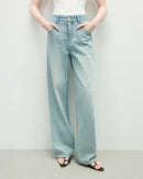 Woman street-styling distressed high-waist straight jeans, sun-fade indigo wash and knee-slit rips give lived-in 90s attitude—92 % cotton / 6 % poly / 2 % elastane keeps structure while adding stretch for 60-75 °F spring-fall days.
