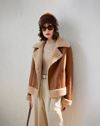 Woman walking city streets in a cropped fleece-lined coat, plush interior traps heat while the neat lapels keep the look polished for work or weekend coffee runs.