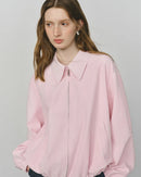 Woman styling a boxy cotton canvas jacket, loose fit and utility pockets give street-to-studio versatility for mild-weather days.