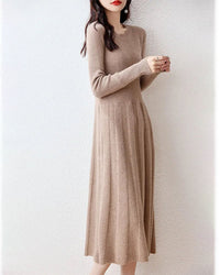 Woman posing in a Merino Wool Knitted Sweater Dress, 100 % superfine Merino rib drapes like jersey—your luxe yet breathable 60-75 °F spring-fall statement.