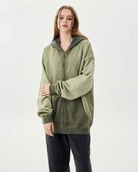 Woman layering an oversized cotton zipper washed hoodie, dropped shoulders and acid-wash finish give 90s street-style vibes—perfect lightweight layer for 60-75 °F spring-fall days.