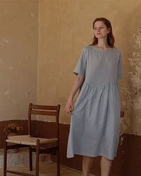 Woman drifting off in a breathable white cotton nightie, tag-free round neck and knee-length drape deliver spa-level softness for sensitive skin.