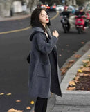 Soft dove-gray, single-breasted cashmere cardigan with hoodie—ribbed texture, horn-style buttons, cozy layer for winter workdays or weekends.