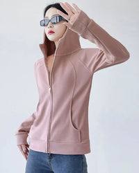 Woman street-styling a slim-fit zipper-up hoodie, 90 % cotton / 10 % spandex fleece contours the body—thumb-hole cuffs and hip-length cut keep you warm on breezy 55-70 °F spring runs.