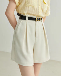 Woman strolling in sand-beige solid-color high-waist shorts, tailored waistband and airy linen-cotton blend keep you cool—your go-to staple for 70-85 °F summer days.