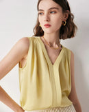 Woman layering a V-neck solid-color commuter mulberry-silk sleeveless shirt, sand-beige 19 momme fabric drapes effortlessly—your breathable, temperature-regulating base for 70-85 °F summer office days.